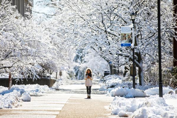 Student walking through snow covered campus