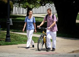 Students walking bike on campus