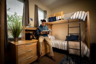 Student reading a book in his dorm