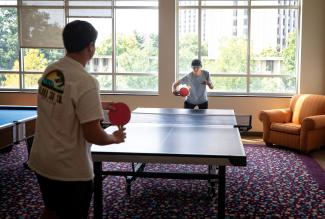 students playing ping pong in dorm common area