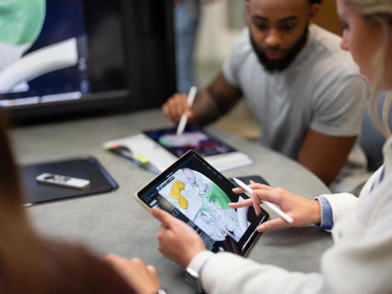 A student working at a desk on an iPad