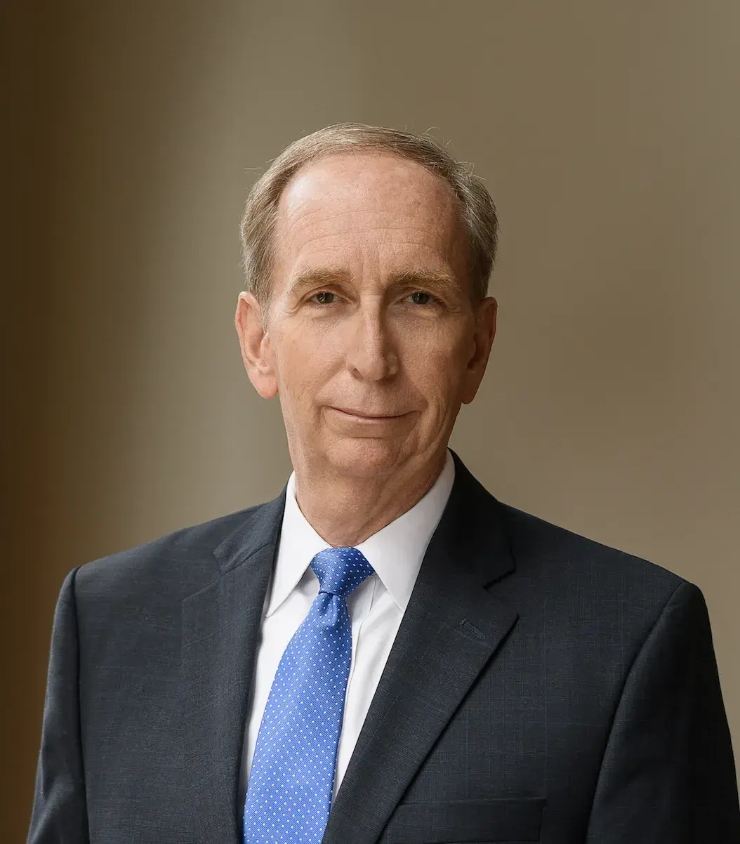 A professional headshot of Mark Birdwhistell. He is wearing a black suit and a blue tie. 